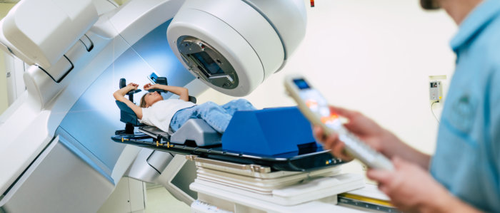 A man undergoing an MRI scan inside a hospital, lying on the machine with medical staff nearby.  