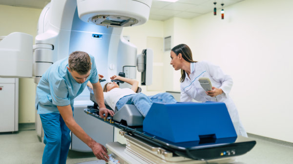 Professional doctors team working while the woman is undergoing radiation therapy